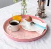Round enamel trinket tray in pink displayed with cup of coffee, orange and an egg.
