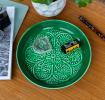Enamel trinket dish in dark green displayed a camera film roll 