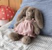 Plush bunny toy with floppy ears, wearing a pink dress