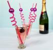 Four pink curly straws each topped with a small pink disco ball decoration.