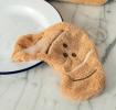 Brown kitchen cloth shaped like a croissant with hanging loop