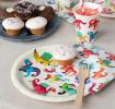 Dinosaur-themed party plate displayes with matching napkins and a cup.