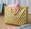 Yellow jumbo storage bag with a pink floral pattern and pink handles.