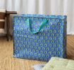 Large blue storage bag with green floral pattern and turquoise handles.