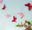 A string garland decorated with colourful feather butterflies hanging against a light background.