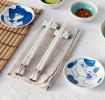 Two cat-themed dipping bowls, two pairs of chopsticks, and two cat-shaped rests.