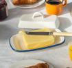 Rectangular white enamel butter dish with a blue rim and a handled lid displayed with butter.