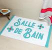 A tufted bath mat in blue and teal with the word “Salle De Bain” on the surface.