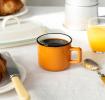 Espresso mug in orange showing with black coffee.