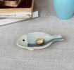 Blue and white ceramic fish‑shaped trinket dish displayed with ring.