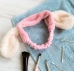 Pink plush fabric hairband with soft white bunny ears.