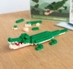 Completed crocodile brick model displayed beside its packaging box.