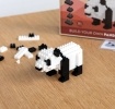 Completed panda brick model displayed beside its packaging box.