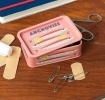 Pink mini storage tin with an illustrated anchovies fish on the front.