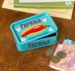 Mini storage tin with paprika illustration on the front.