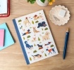 Notebook with illustrated dogs in a park scene on the cover.
