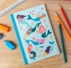 Notebook with illustrated mermaids, sea creatures, and shells on a light aqua cover.