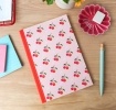 Pink notebook with cherry design on the cover.