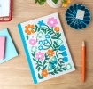 Notebook with colourful illustrated flowers, leaves, and butterflies on the cover.