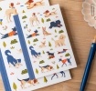 Notebook with illustrated dogs in a park scene on the cover.