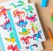 Notebook with colourful dinosaurs on a light background.