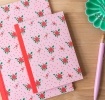 Pink notebook with a french rose design on the cover.