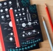 Notebook with space‑themed diagrams, including moon phases, planets, and a rocket on the cover.