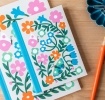Notebook with colourful illustrated flowers, leaves, and butterflies on the cover.
