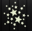 Glow‑in‑the‑dark star shapes in different sizes on a black background.