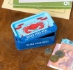 Blue mini storage tin with an illustrated crab on the front.