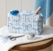 Light blue quilted makeup bag with a bow pattern and tassel.