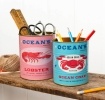 Two Ocean’s Brand storage tins featuring lobster and crab illustrations in pink and blue.