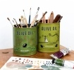 Two green olive oil storage tins, featuring illustrated trees and olives.