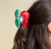 Hair claw clip featuring a sweet cherry design in red, green and white, with hints of marbling and translucence. 