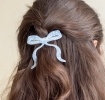 Hair clip featuring a pretty bow design in blue, with hints of marbling and translucence. 