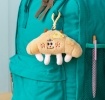 Fluffy croissant bag charm with smiley face, cheese patch and clip attachment