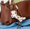 Plush sausage dog bag charm with brown spots, cord strap and clip.