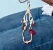 Beige cord phone strap with decorative flower and bead charms shown attached to a phone.