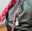 Pink keyring bag charm with a metal clip, decorated with a white dog and red strawberry.