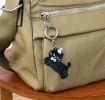 Black cat-shaped keyring with comb teeth, blue bow and hat attached to a silver ring.