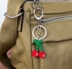 Cherry keyring with green stems and silver ring and clip attachment.