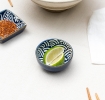 Round ceramic dipping bowl with blue wave pattern shown with lime wedges.