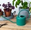 Green metal watering can with curved handle and long spout.