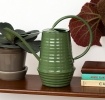 Dark green ribbed metal watering can with handle and long spout