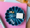 Blue enamel flower-shaped trinket dish holding clips and small items