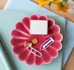 Red enamel flower-shaped trinket dish holding clips and small items