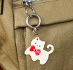 Cream cat-shaped keyring with red bow and silver ring attachment.
