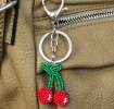Cherry keyring with green stems and silver ring and clip attachment.