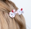 Set of two mini rabbit-shaped hair claw clips with white faces and pink ear details.