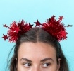 Red party headband with tinsel pom-poms and star decorations.
